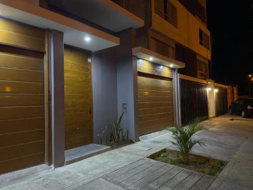 a house with wooden garage doors on a street at night at Hurin Hotel in Ica