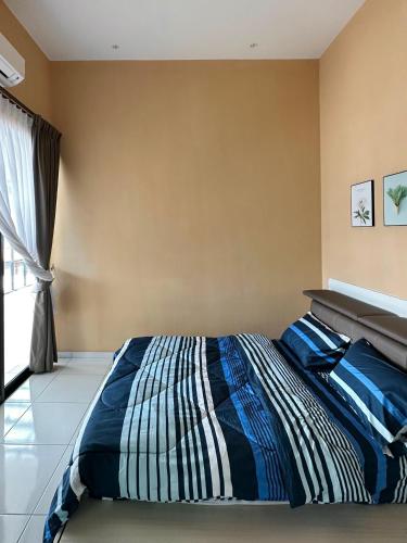 a bedroom with a bed with a striped comforter at Peak Homestay@Ipoh Perak Malaysia 10-14Pax 5R/6B in Lahat