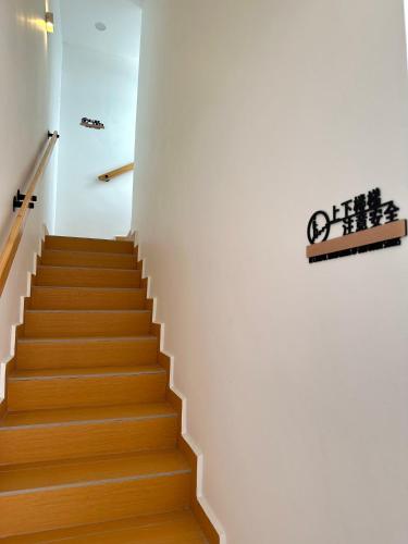 a staircase with white walls and wooden floors at Peak Homestay@Ipoh Perak Malaysia 10-14Pax 5R/6B in Lahat