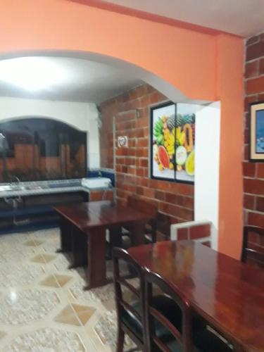 une salle à manger avec deux tables et une cheminée dans l'établissement nice house in Ecuadorian Amazonia, à Tena