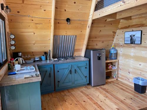 a kitchen in a log cabin with a refrigerator at Cabaña El Respiro in El Diamante