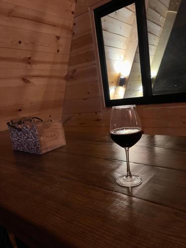 a glass of wine sitting on a table in a cabin at Cabaña El Respiro in El Diamante
