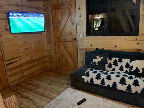 uma sala de estar com um sofá e uma televisão de ecrã plano em Cabaña El Respiro em El Diamante