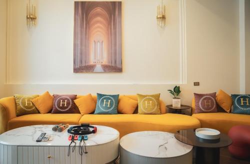 a living room with a yellow couch and pillows at 海角瑞拉斯包棟民宿- Cape Relax Villa in Hengchun