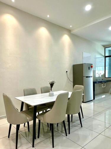a dining room with a table and chairs and a refrigerator at Peak Homestay@Ipoh Perak Malaysia 10-14Pax 5R/6B in Lahat