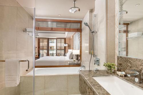 a bathroom with a tub and a sink and a shower at Henann Premier Coast Resort in Panglao