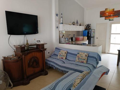 a living room with a couch and a flat screen tv at Casa de playa in Machalilla