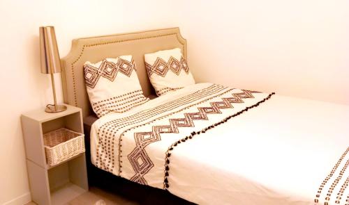 Una cama con dos almohadas encima. en Appartement aux portes de Paris, en Villeneuve-la-Garenne