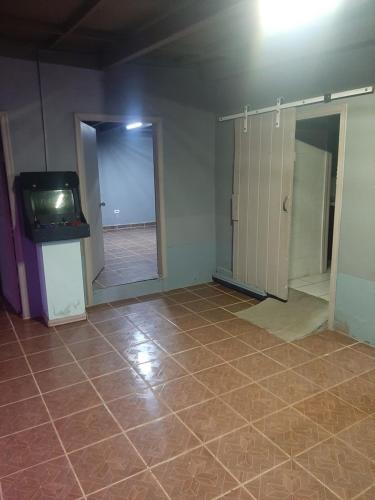 Habitación vacía con TV y suelo de baldosa. en Solorzanorenta, en Ensenada