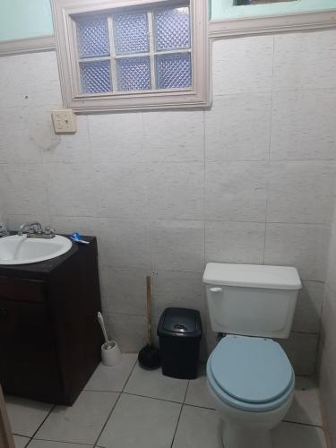 baño con aseo y lavabo y ventana en Solorzanorenta, en Ensenada