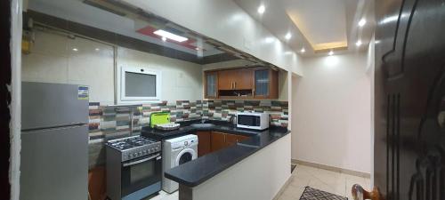 Luxury furnished apartment للعائلات فقط overlooking the sea في الإسكندرية: مطبخ صغير مع موقد وثلاجة