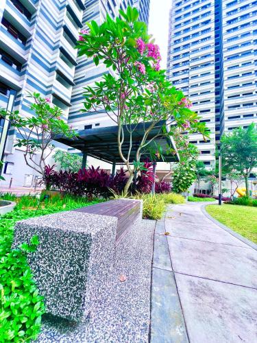 a park with a bench and a tree and buildings at Legoland-8min walk at Kairos Comfort Spacious Suite for Families 1-12pax in Nusajaya