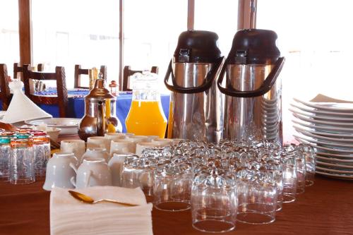 a table with glasses and bottles and plates on it at Aladdin merzouga camp in Merzouga