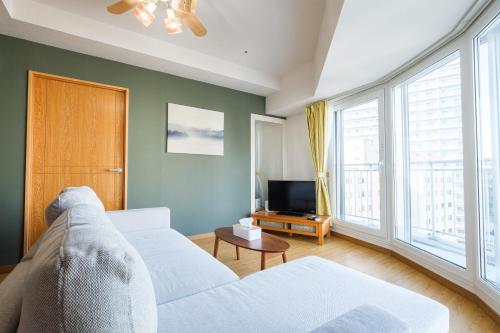 a living room with a couch and a tv at AMS TOWER 1106 in Sapporo