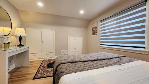 1 dormitorio con cama y ventana en The Serene Haven Modern 2 Queen Bed Full Apartment, en St. Catharines