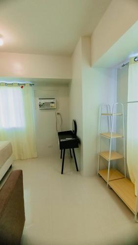 Zimmer mit einem schwarzen Stuhl und einem Regal in der Unterkunft Mabolo Taft East Gate in Cebu City