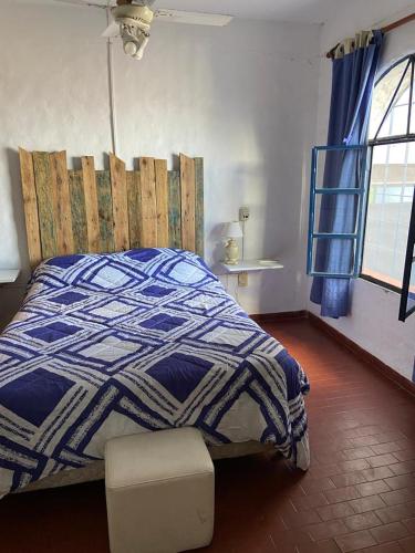 Un dormitorio con una cama azul y blanca y una ventana en CASA JUNTO AL RIO en Paraná