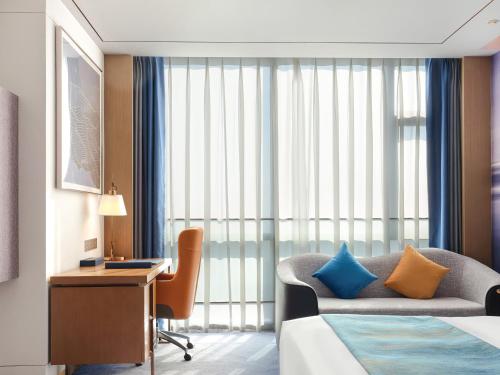 a hotel room with a bed and a desk and a couch at Novotel Changsha International Exhibition Center in Changsha