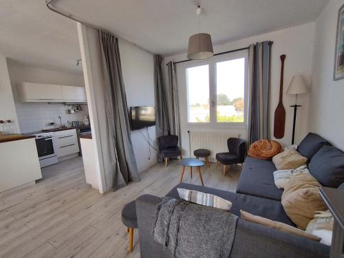 un salon avec un canapé bleu et une cuisine dans l'établissement Grande maison avec jardin, proche plage, 4 chambres, terrasse, pour 8 personnes - Île d'Oléron - FR-1-778-22, à Grand-Village-Plage