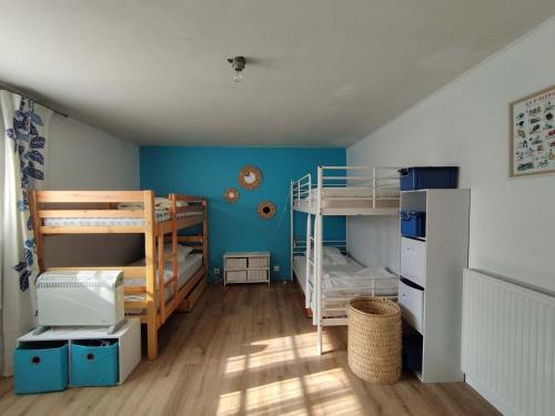 Cette chambre dispose de 2 lits superposés et de murs bleus. dans l'établissement Grande maison avec jardin, proche plage, 4 chambres, terrasse, pour 8 personnes - Île d'Oléron - FR-1-778-22, à Grand-Village-Plage