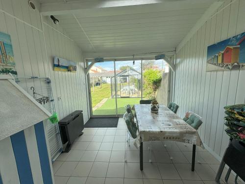une véranda avec une table et des chaises dans l'établissement Maison 2 Chambres avec Jardin, Quartier La Chaume, Proche Plage et Commerces - FR-1-197-591, à Les Sables-dʼOlonne
