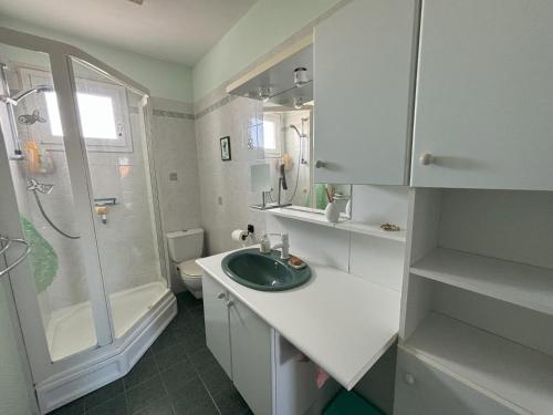 une salle de bain blanche avec un lavabo et une douche dans l'établissement Maison 2 Chambres avec Jardin, Quartier La Chaume, Proche Plage et Commerces - FR-1-197-591, à Les Sables-dʼOlonne
