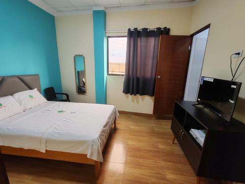 a bedroom with a bed and a flat screen tv at HOTEL EL TREBOL in Yurimaguas