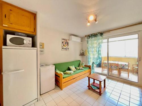 - un salon avec un canapé vert et un réfrigérateur dans l'établissement Appartement 2 pièces climatisé avec parking, à 150m de la plage et proche commerces, Séte - FR-1-338-565, à Sète