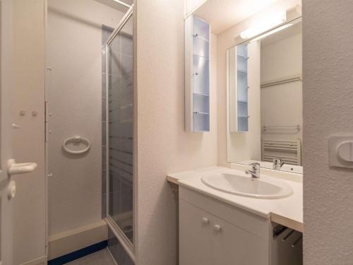 une salle de bain avec un lavabo et une douche en verre dans l'établissement Cauterets : Duplex 4 pers avec balcon, parking, proche thermes et randonnées - FR-1-401-289, à Cauterets