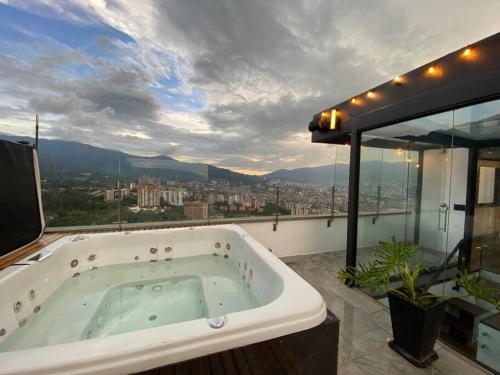 a bath tub in a bathroom with a view of a city at penthouse luxurytravelhome poblado in Medellín