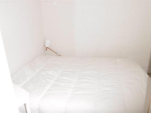 uma cama branca num quarto branco com um candeeiro em Appartement Les Angles, 2 pièces, 4 personnes - FR-1-295-200 em Les Angles