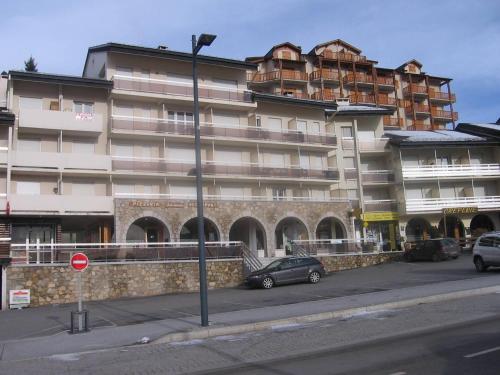 um grande edifício com carros estacionados em frente em Appartement Les Angles, 2 pièces, 4 personnes - FR-1-295-200 em Les Angles