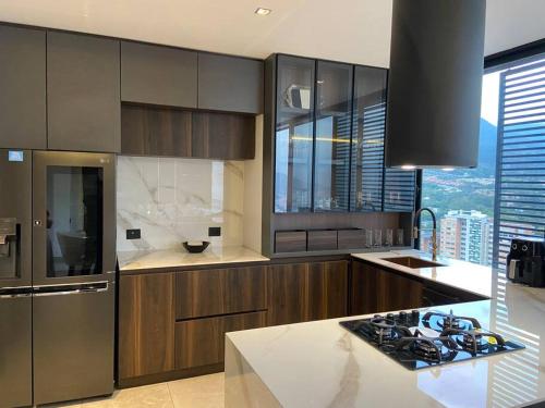 a kitchen with stainless steel appliances and a large window at penthouse luxurytravelhome poblado in Medellín