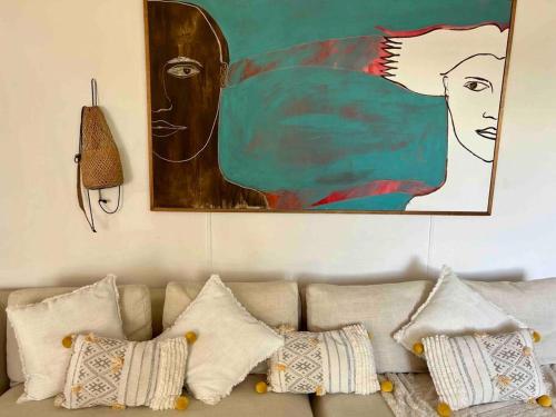 a living room with a couch with pillows and a painting at Cosy Home in Heart of Subiaco in Perth