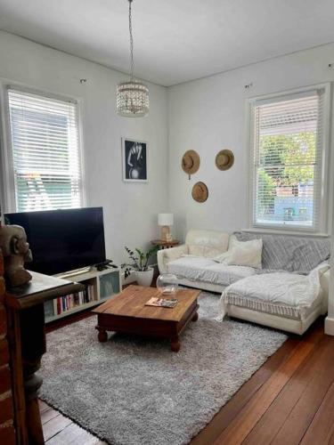 a living room with a couch and a coffee table at Cosy Home in Heart of Subiaco in Perth