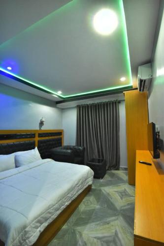 um quarto com uma cama e uma televisão num quarto em La Vista Imperial Hotel em Enugu