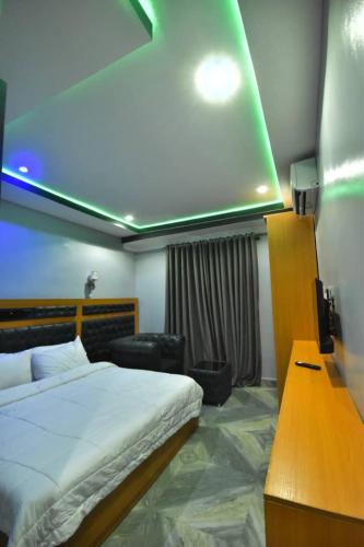 pokój hotelowy z łóżkiem, biurkiem i odwrotnością w obiekcie La Vista Imperial Hotel w Enugu