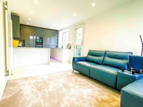 a living room with a blue couch and a kitchen at Luxury Apartment London in London