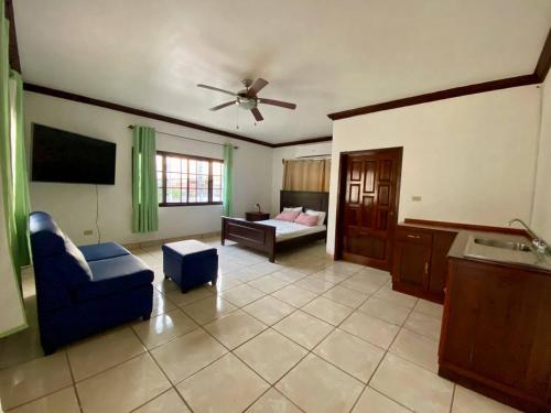 - un salon avec un fauteuil bleu et un canapé dans l'établissement MATS, à San Pedro Sula