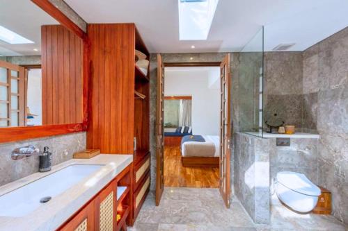 1 dormitorio y baño con bañera y lavamanos. en Alyssum 2 BR Private Pool & Jacuzzi ZN61, en Ubud