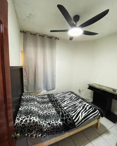 Schlafzimmer mit einem Zebra-Bett und einem Deckenventilator in der Unterkunft Depa en el centro de Calvillo G in Calvillo