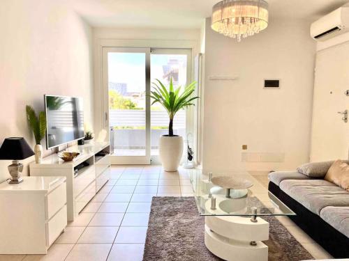 een woonkamer met een bank en een glazen tafel bij Luxury Apartment Centre. Pool. Beach and Shopping in Lido di Jesolo