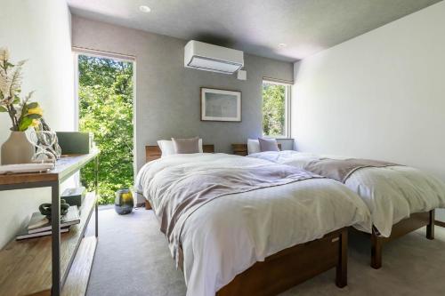 留壽都的住宿－翠葉 ルスツ，一间卧室设有一张大床和一个窗户。