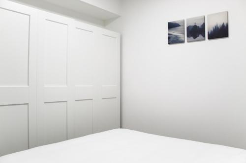 a white closet with two pictures on the wall at Luxury Family Apartment #28 By Hashdera Eilat in Eilat