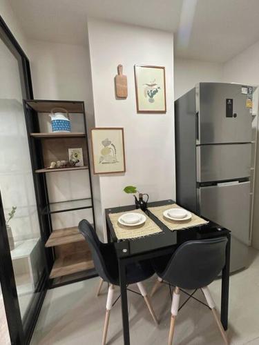 a black table with two chairs and a refrigerator at Cozy,convenient,shopping area in Chiang Mai