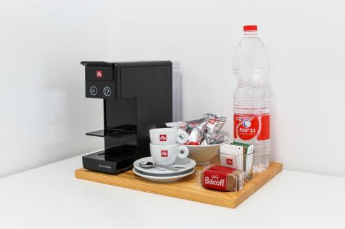 a coffee maker with cups and a bottle of water at Luxury Family Apartment #28 By Hashdera Eilat in Eilat