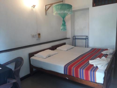 a small bedroom with a bed and a chair at Drop Hostel in Kandy