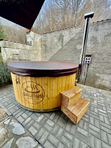 a large wooden barrel with a wooden table and stairs at Chata Hana Donovaly in Donovaly