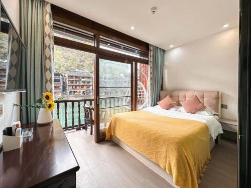 a bedroom with a bed and a balcony at Fenghuang Ancient Town Lazy Cat Riverside Inn in Fenghuang