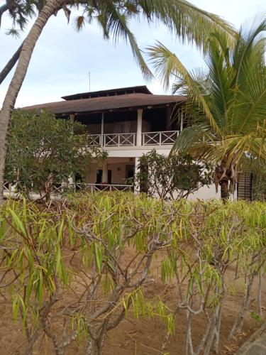 Mkuu House في ماليندي: منزل على الشاطئ مع أشجار النخيل